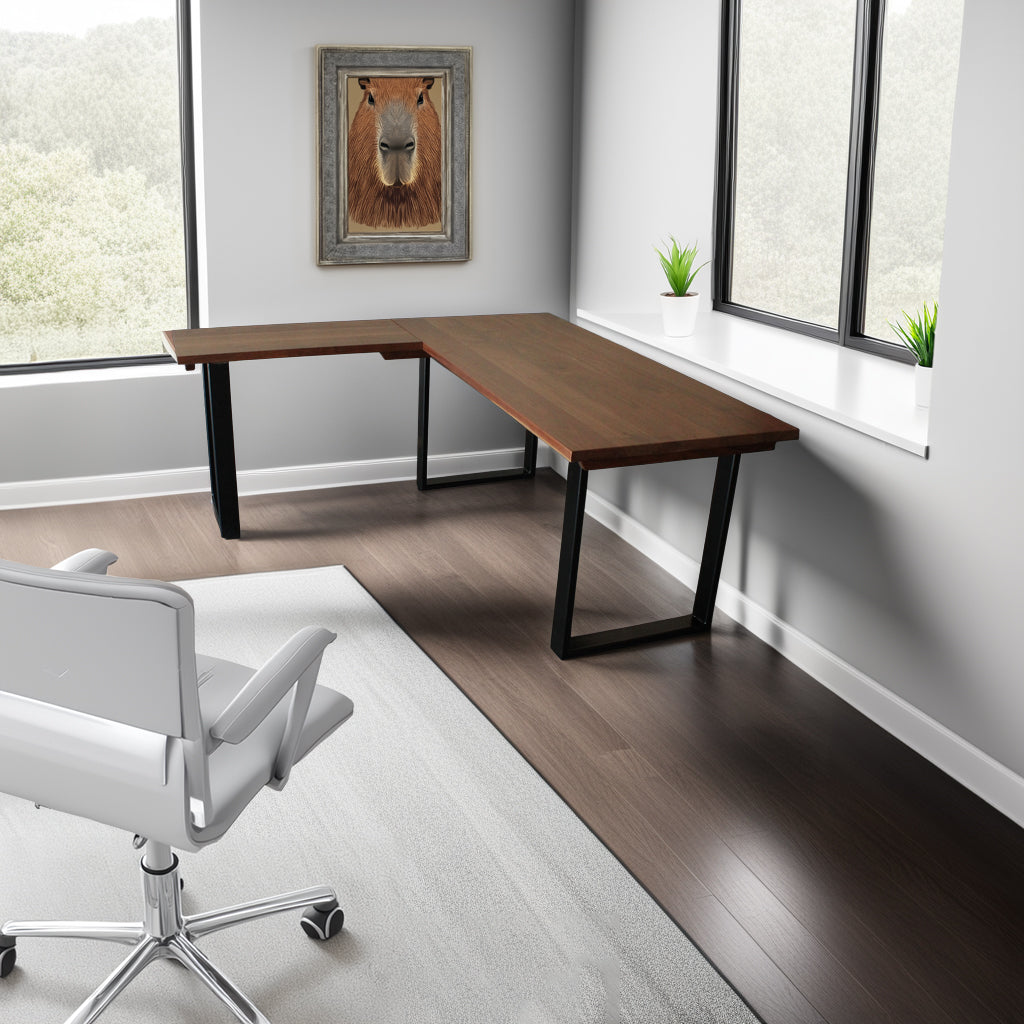 A solid hardwood L‑shaped work surface with sleek U‑shaped metal legs, arranged in a bright, modern corner office