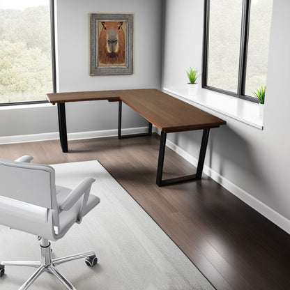 A solid hardwood L‑shaped work surface with sleek U‑shaped metal legs, arranged in a bright, modern corner office